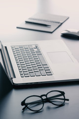 Laptop, glasses and notebook