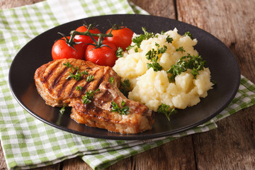 Grilled pork T-bone steak garnished with mashed potatoes close-up. horizontal