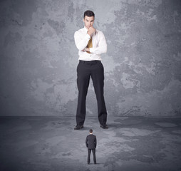 Big boss looking at tiny coworker