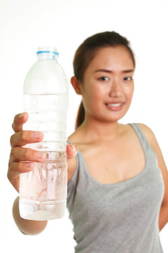 Young woman drinking water on white background.