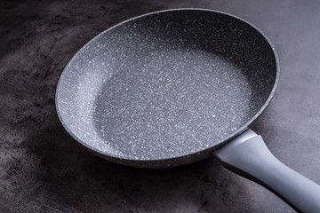 Ceramic pan on concrete kitchen board. Kitchen utensil. Empty pan.