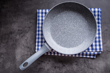 Ceramic pan on concrete kitchen board. Kitchen utensil. Empty pan.