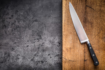 Kitchen knife on concrete or wooden board.