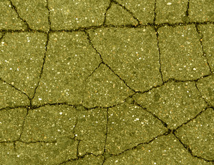 Damaged yellow toned old asphalt road.
