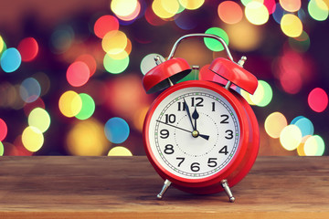 Red retro alarm clock at twelve o'clock on the background with b