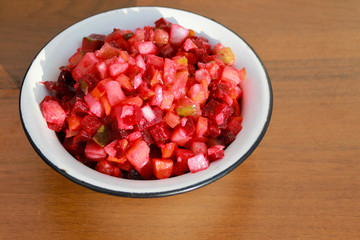 Russian beet salad vinaigrette in rustic bowl on wooden table