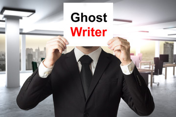 businessman hiding face behind sign ghost writer