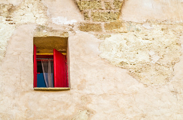 red shutters window on grunge and scraped wall