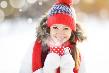 happy young woman with a cup of hot tea in winter  walk
