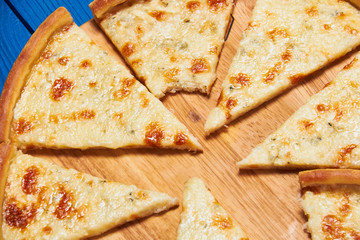 Pizza with three cheeses./Pizza with three cheeses on a wooden board blue.