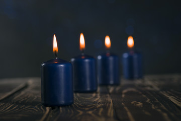 Lit four blue candles on wooden counter
