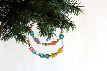 Happy New Year and merry Christmas card beaded letter garland on fir tree brunch  isolated on white background. Copyspace place for your text and logo. Concept frame corner for label or banner.