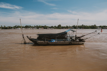 Photo of a small boat in mekong river on the sunny day, vintage color style.