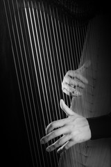 Obraz premium Harp strings Hands playing musical instruments.