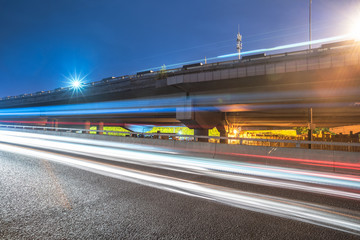 blurred traffic light trails on road at night in China.