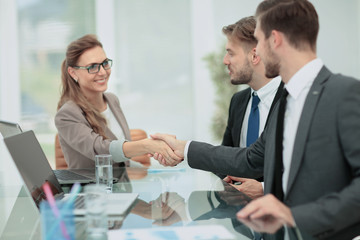 Happy business partners shaking hands in an office