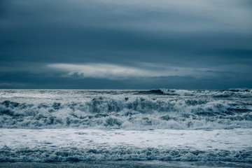 Naklejka na ściany i meble stormy waves breaking on beach