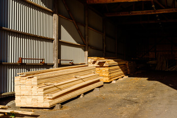 Thin planks inside an open storage building.