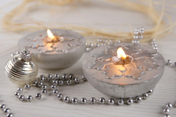 Silver  candles  with snowflakes. Winter, Christmas decoration on wooden  background

