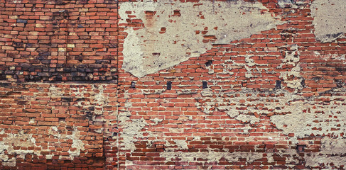 Old vintage red brick wall with fallen plaster for background