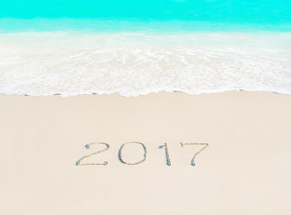 Year 2017 season concept on azure ocean tropical beach sand