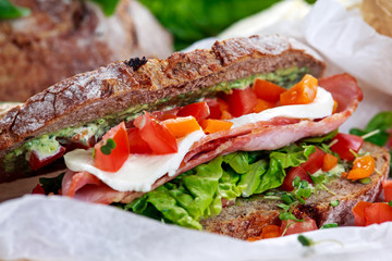 Fresh BLT Sandwich with Bacon Lettuce Tomato and Mozzarella on crumpled paper