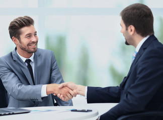 Two business colleagues shaking hands during meeting