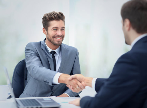 Two business colleagues shaking hands during meeting