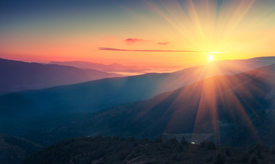Panoramablick auf den farbenfrohen Sonnenaufgang in den Bergen. Gefiltertes Bild: Kreuz verarbeiteter Vintage-Effekt.