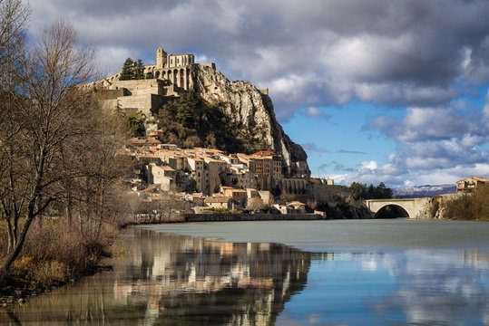 Citadel of Sisteron and Durance River in hiver with clouds in afternoon light. Sisteron and its fortifications is located in the Southern Alps (Alpes de Haute Provence). France