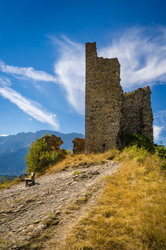 Ruins of Saint-Firmin castle (also known as "Le Fort") and a bench at the entrance of Valgaudemar valley in the Hautes-Alpes. Summer in the Southern French Alps. France
