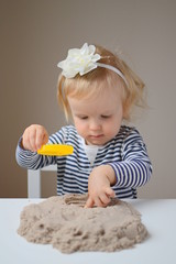 Little baby girl age of 1,6 years play with kinetic sand
