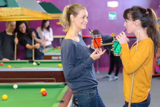 Women in pool hall with drinks