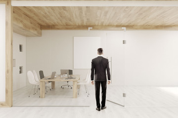 Man entering conference room with glass walls and doors