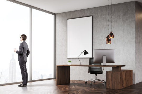 Man with coffee in CEO office with panoramic window and poster