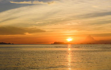 Naklejka na ściany i meble Panoramic golden sunset sky and tropical sea at dusk