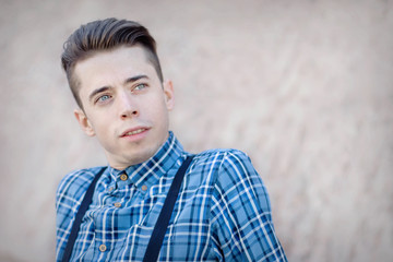 Confident young man wearing blue square shirt over neutral background