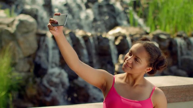 Selfie girl. Woman selfie outdoor. Girl taking selfie at park. Selfie woman. Latin woman selfie portrait. Happy girl showing v sign. Phone selfie. Girl taking selfie with smart phone