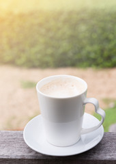 Morning cup of coffee with green garden background