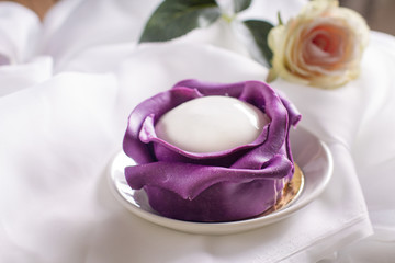 Obraz na płótnie Canvas Пирожное фиолетовая роза на светлом фоне