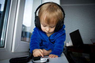 Fototapeta na wymiar Cute baby boy listening music at headphones 