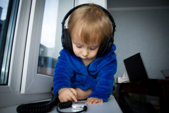 Cute baby boy  listening music at headphones 