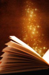 an open old book with gold stars over grunge background like a concept for magic book