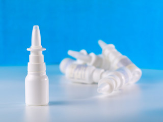 nasal spray bottle in front of other bottles pile, shallow depth of field, advertisement concept