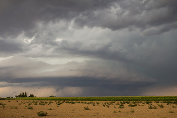 Fototapeta na wymiar A supercell thunderstorm creates an eerie scene over farmland in eastern Colorado.