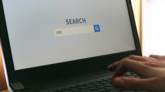 Man working on notebook laptop computer, searching for jobs online on internet.