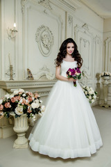 Fototapeta premium gorgeous bride in luxury wedding dress. Wedding make up and hairstyle, wedding jewelry. gorgeous wedding bouquet of various flowers. purple orchids 