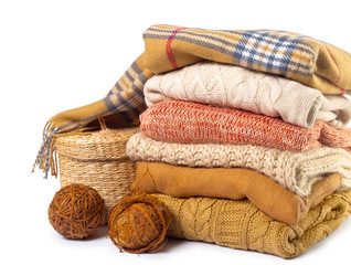 Stack of various sweaters isolated on white background