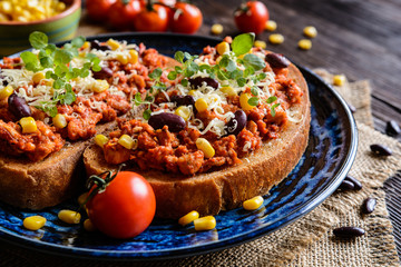 Fried toasts with chicken meat, tomato, chili, pepper, beans and