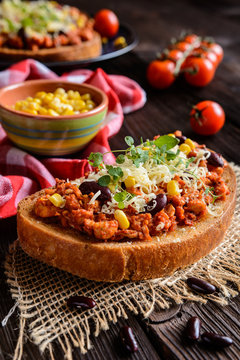 Fried toasts with chicken meat, tomato, chili, pepper, beans and